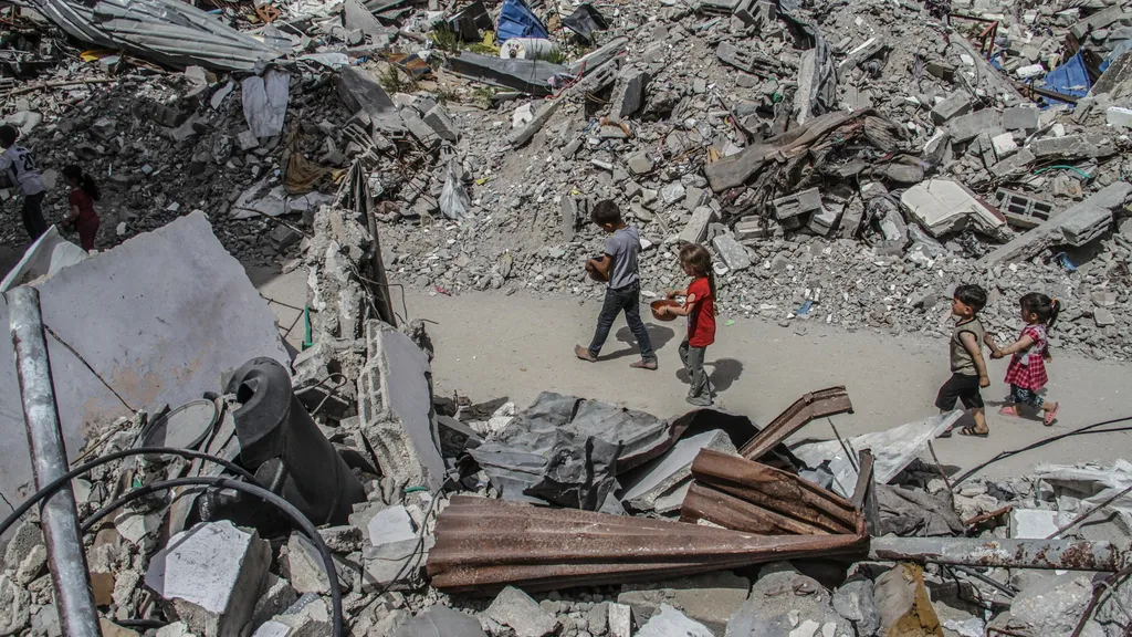 Hilfsorganisation Cadus in Gaza: Diese Aufnahme vom Montag zeigt Kinder auf dem Weg zurück von der Essensausgabe im zerstörten Flüchtlingslager Dschabalija im Norden des Gazastreifens. Der Fotograf Mahmoud Issa verharrt dort.
